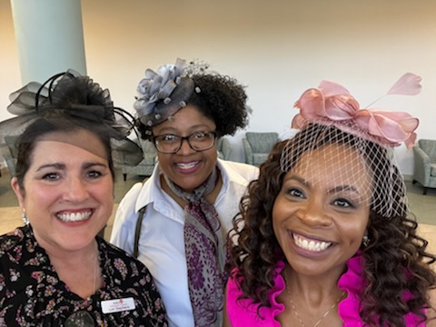 Photo of L'Oreal Stephens, Leah Lyons, and Chandra Story wearing fancy hats with bows. 