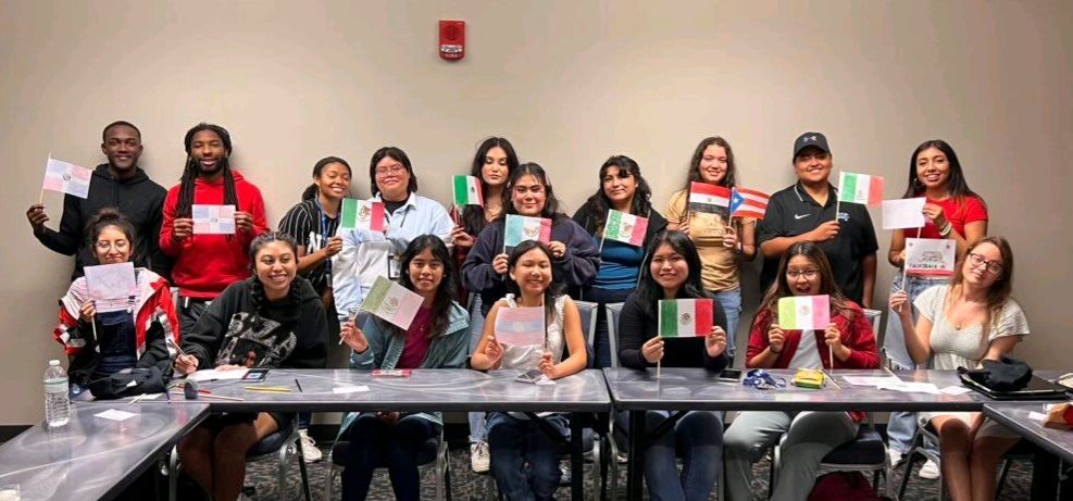 La Comunidad members at table holding flags